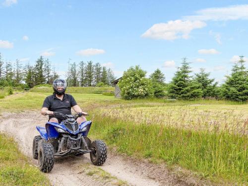 a man riding a quad bike on a dirt road at Vigsø Holiday Center in Hanstholm