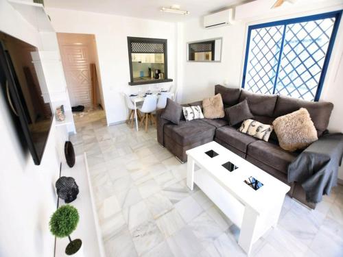 ein Wohnzimmer mit Sofa und Tisch in der Unterkunft Holiday home in Roquetas de Mar by the sea in Roquetas de Mar
