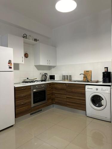 a kitchen with a white refrigerator and a dishwasher at Amazing Two-Bedroom Apartment in Residence Lukomorye D5 with scenic view in Karavas