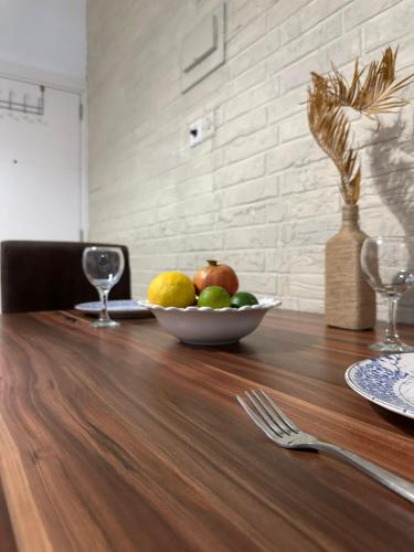 a bowl of fruit on a wooden table at Amazing Two-Bedroom Apartment in Residence Lukomorye D5 with scenic view in Karavas