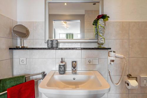 a bathroom with a sink and a mirror at Landhaus Christophorus in Forbach