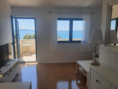 a white living room with a view of the ocean at Apartments with sea view in Kožino