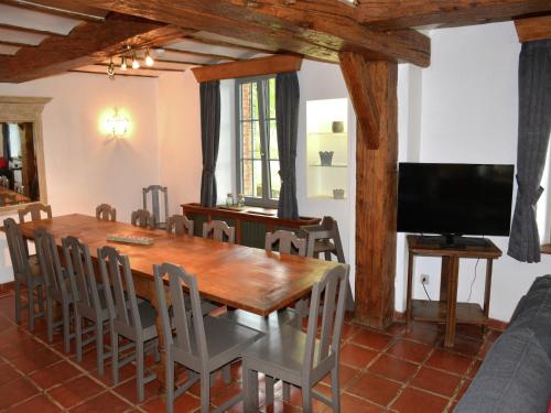 a dining room with a wooden table and chairs at Vintage Farmhouse with Garden, Roofed Terrace in Gouvy