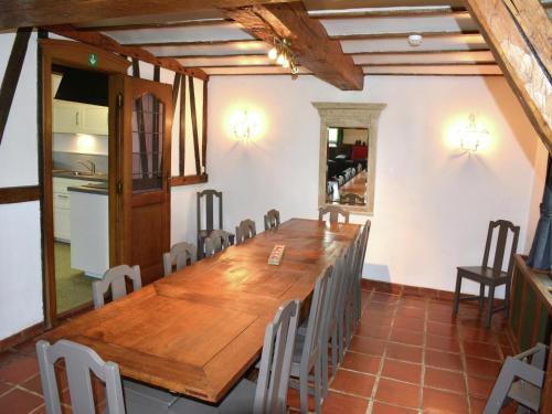 a dining room with a wooden table and chairs at Vintage Farmhouse with Garden, Roofed Terrace in Gouvy
