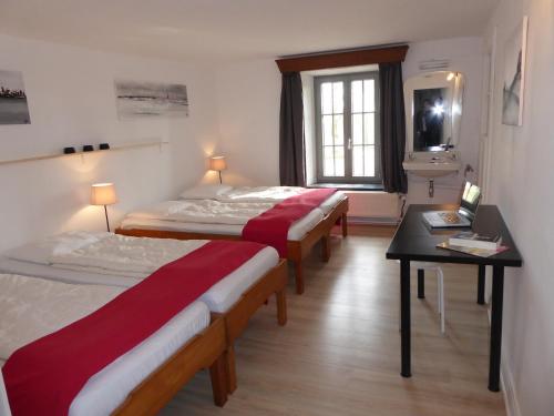 a room with three beds and a table and a window at Vintage Farmhouse with Garden, Roofed Terrace in Gouvy