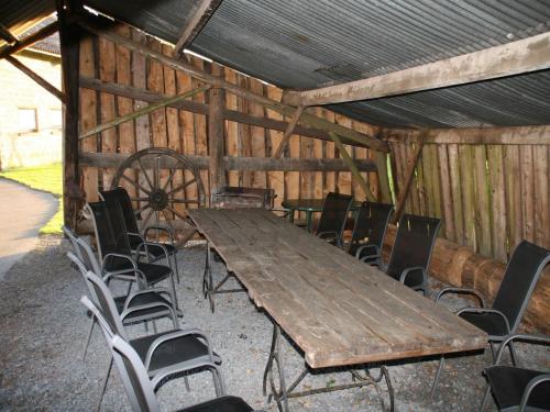 a wooden table and chairs in a barn at Vintage Farmhouse with Garden, Roofed Terrace in Gouvy
