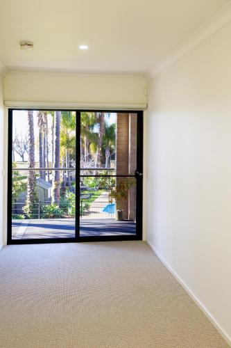 an empty room with a large glass door at Elsinor Townhouse 1 in Mulwala
