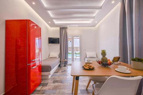 a living room with a table and a red refrigerator at Depis private villas Plaka Naxos in Plaka