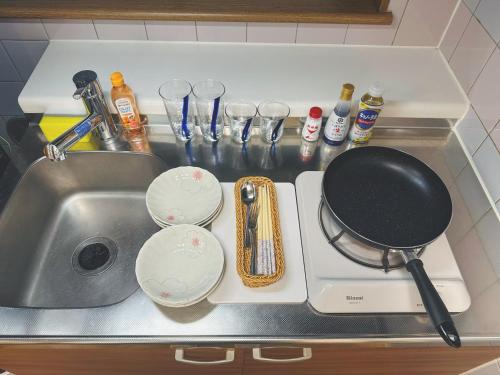 a kitchen sink with a frying pan and dishes on it at 4min to 東新宿Shinjuku in Tokyo