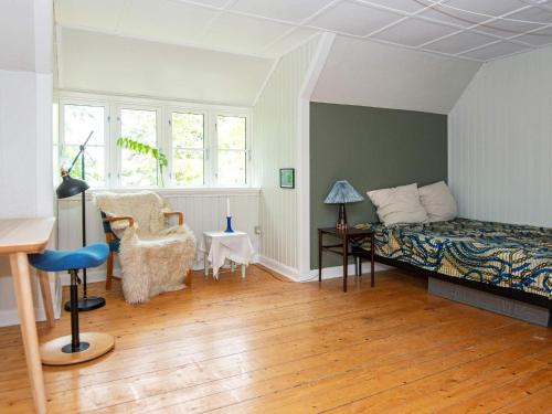 a bedroom with a bed and a table and a chair at 20 person holiday home in Ulfborg in Ulfborg