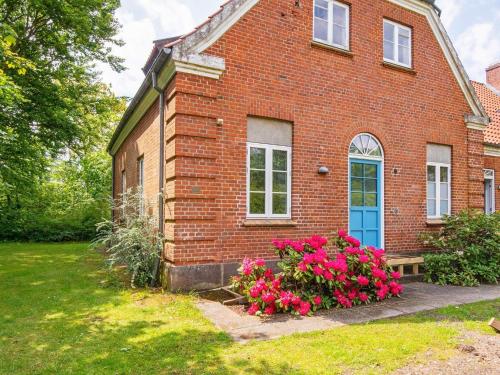 a brick house with a blue door and flowers at 20 person holiday home in Ulfborg in Ulfborg