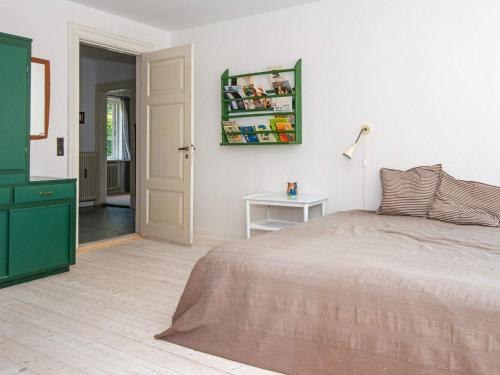a bedroom with a bed and a table with a lamp at 20 person holiday home in Ulfborg in Ulfborg