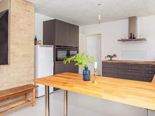 a kitchen with a wooden table and a refrigerator at 20 person holiday home in Ulfborg in Ulfborg