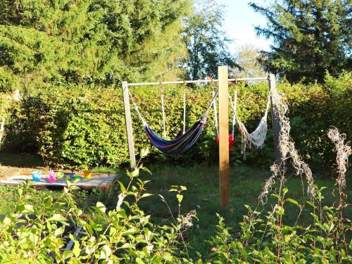 a hammock in a yard with trees and bushes at 20 person holiday home in Ulfborg in Ulfborg