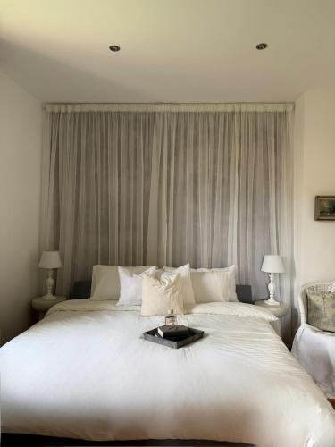 a large white bed with a tray on top of it at Boutiquezimmer Duchesse in Mirepoix