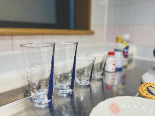 four empty glasses sitting on a kitchen counter at 4min to 東新宿Shinjuku in Tokyo