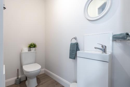 a white bathroom with a toilet and a sink at Gardenview Manor in Moy