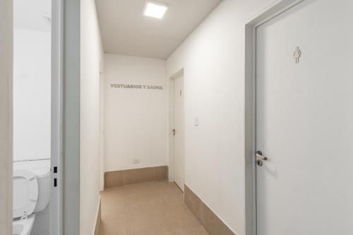 an empty bathroom with a toilet and a door at Departamento Premium en Puerto Norte con vista al río in Rosario