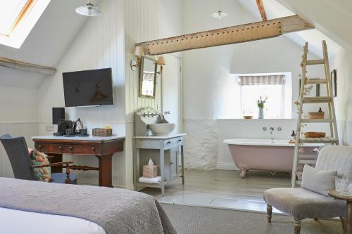 a bedroom with a bed and a bath tub and a sink at The Swan in Wedmore