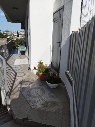 a balcony with a door and some plants and a table at Alexia Room in Funchal