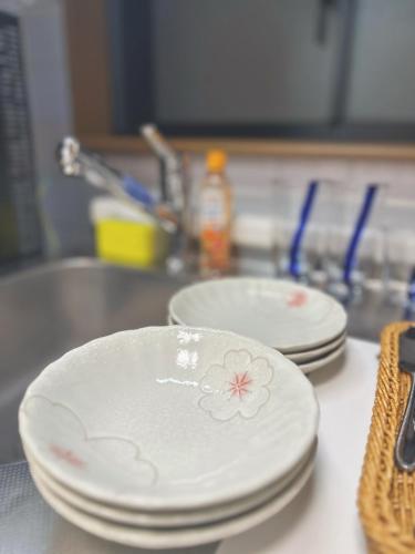 two white plates sitting on a counter next to a sink at 4min to 東新宿Shinjuku in Tokyo