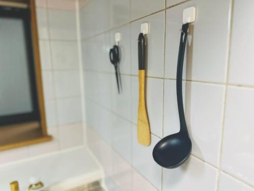 two kitchen utensils are hanging on a wall at 4min to 東新宿Shinjuku in Tokyo