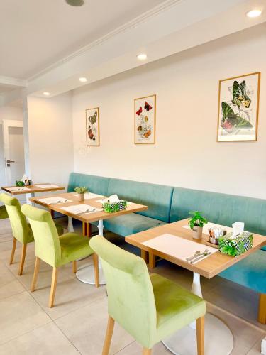 a restaurant with wooden tables and green chairs at Krystal Boutique Mansion in Hunedoara