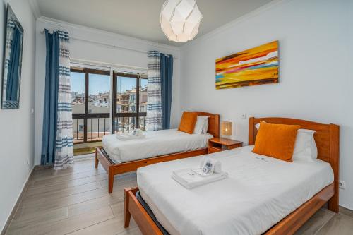 Dos camas en una habitación con ventana. en Stunning sea view apartment in Burgau #1897, en Burgau