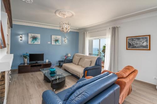 a blue living room with a couch and a tv at Stunning sea view apartment in Burgau #1897 in Burgau