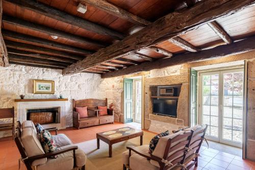 a living room with a fireplace and a tv at Feel Discovery Casa Da Capela Douro Valley in Armamar