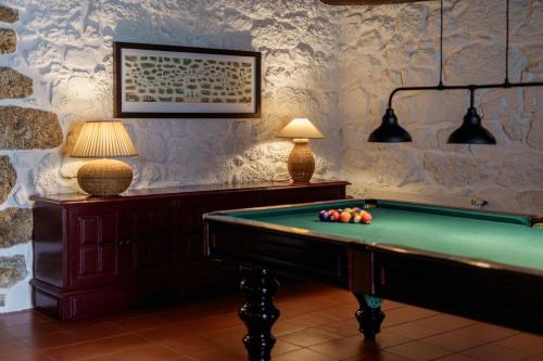 ein Zimmer mit einem Billardtisch und zwei Lampen in der Unterkunft Feel Discovery Casa Da Capela Douro Valley in Armamar