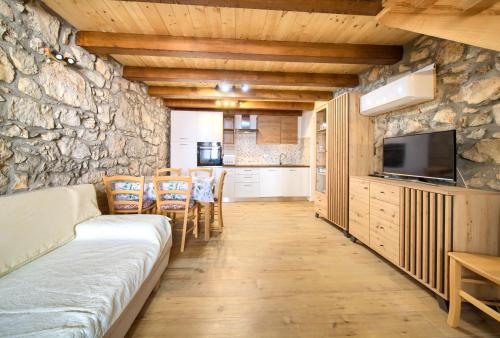 a living room with a couch and a stone wall at Kamena vila in Kornić