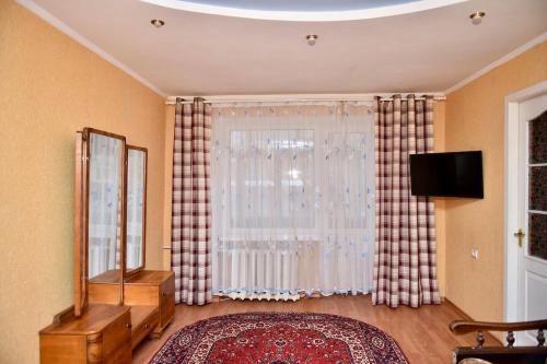 a living room with a large window with curtains at 2-к квартира в центрі, ТЦ Київ in Sumy