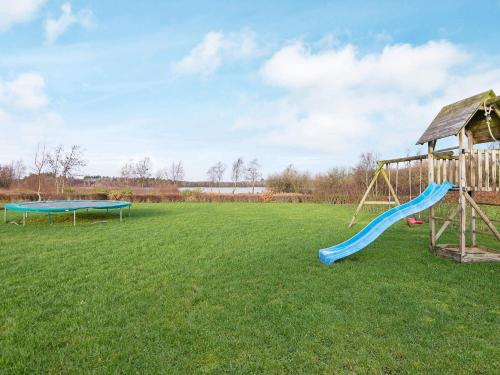 a playground with two swings and a slide at 10 person holiday home in Ansager-By Traum in Ansager