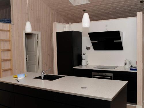 a kitchen with a sink and a black refrigerator at 10 person holiday home in Ansager-By Traum in Ansager