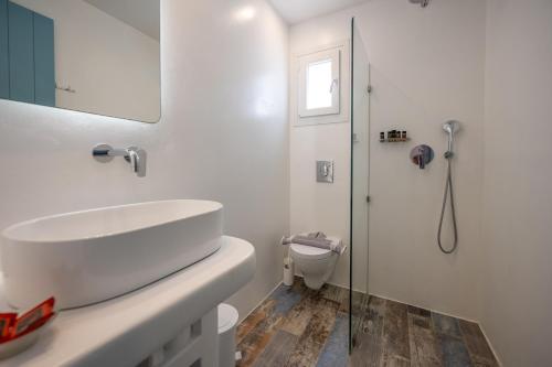 a white bathroom with a sink and a shower at Depis private villas Plaka Naxos in Plaka