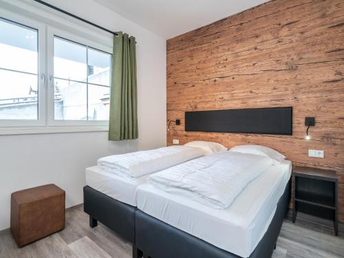 a bedroom with a large bed with a wooden wall at Chalet in Alpendorf near Ski Slopes in Alpendorf