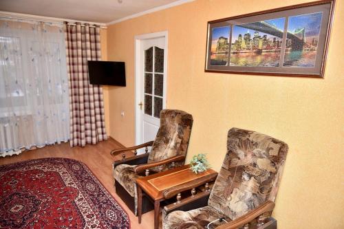 a living room with two chairs and a tv at 2-к квартира в центрі, ТЦ Київ in Sumy