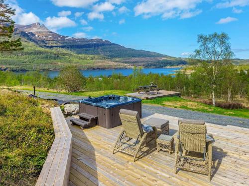 a patio with a barbecue and two chairs and a table at 4 star holiday home in Inndyr in Inndyr