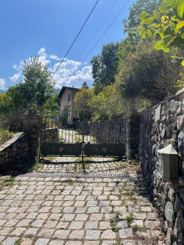 a stone fence and a stone walkway next to a stone wall at Villa fleurie - maison familiale, véranda et jardin in Tende