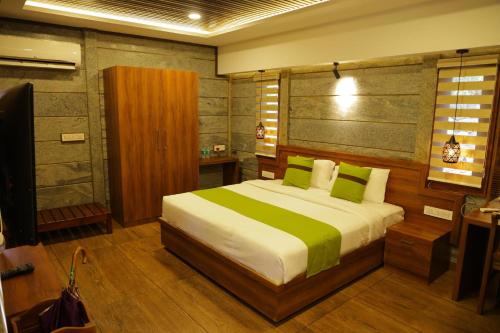 a bedroom with a large bed with green pillows at Hortus Malabaricus Garden Resort in Cheruthuruthi