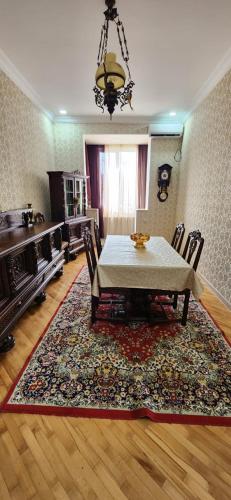 Un comedor con una mesa y sillas sobre una alfombra. en Gust house, en Kutaisi