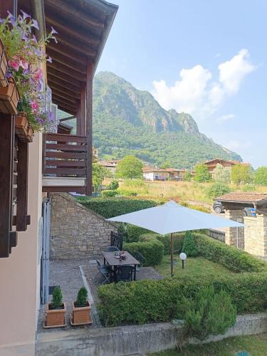 a patio with a table and an umbrella at Il Mirtillo Rosso - Anfo in Anfo