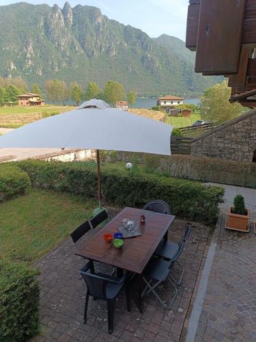 a wooden table with an umbrella on a patio at Il Mirtillo Rosso - Anfo in Anfo