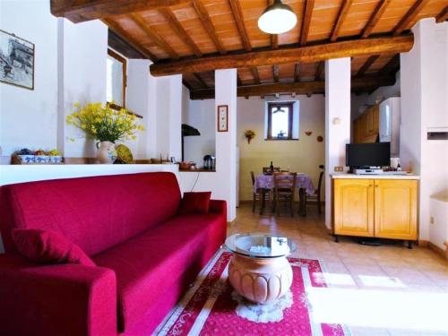 Una sala de estar con un sofá rojo y una mesa. en Charming Stone Retreat, en Castiglion Fiorentino