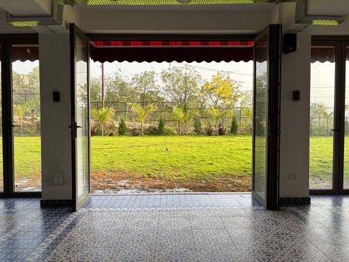 an open door with a view of a field at Cullinan Hotel & Restaurant in Bilāspur