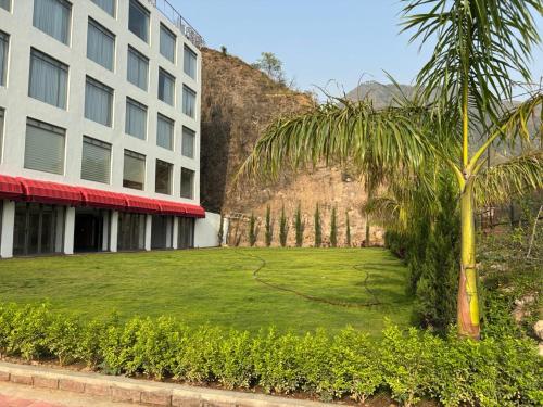 a palm tree in front of a building at Cullinan Hotel & Restaurant in Bilāspur