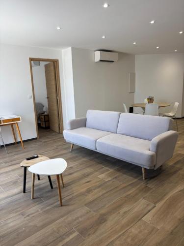 a living room with a couch and a table at Rez de villa Grand T2 in Sarrola-Carcopino