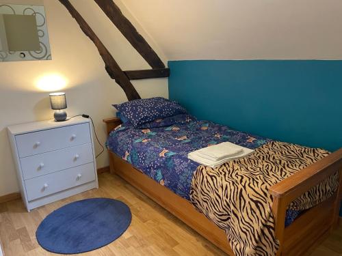 una piccola camera con letto e testiera blu di La Maison de Maître, Loire Gîte a Fléré-la-Rivière