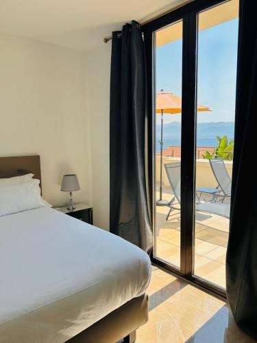 - une chambre avec un lit et une vue sur une terrasse dans l'établissement Hôtel Villa Martini, à Ajaccio